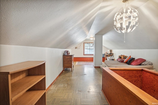 bedroom with an inviting chandelier, parquet flooring, vaulted ceiling, and a textured ceiling