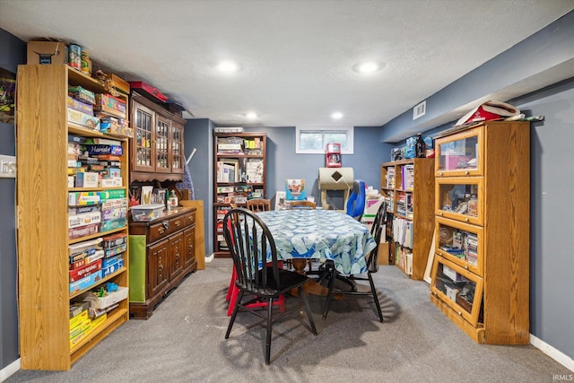 carpeted dining area with a textured ceiling