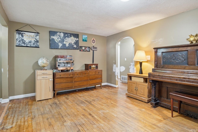 miscellaneous room with a textured ceiling and light hardwood / wood-style floors