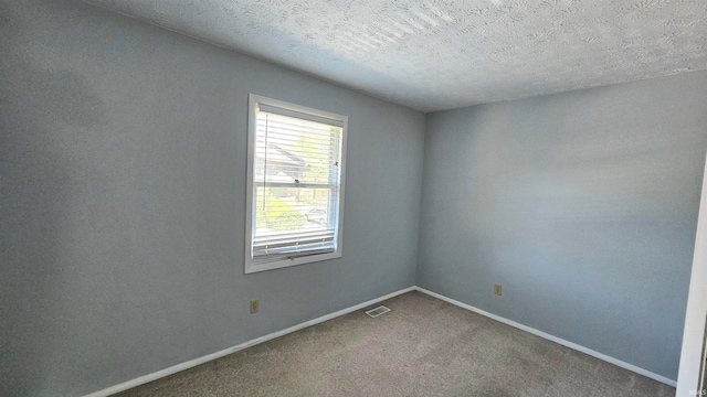 spare room with a textured ceiling and carpet floors