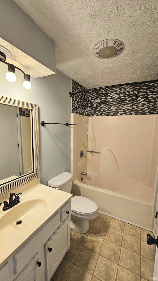 full bathroom featuring vanity, a textured ceiling, washtub / shower combination, tile patterned flooring, and toilet