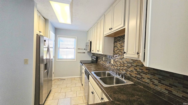 kitchen with backsplash, a textured ceiling, appliances with stainless steel finishes, and sink