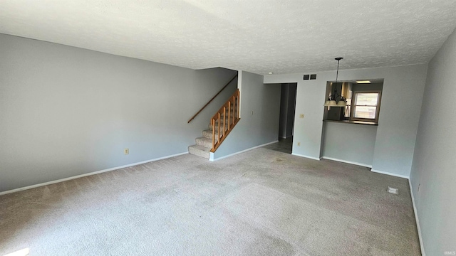 interior space featuring a textured ceiling, carpet flooring, and a chandelier