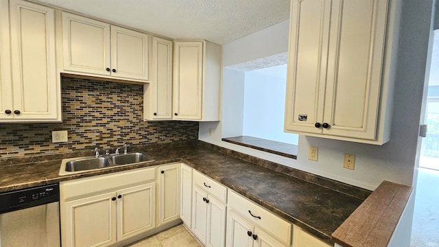 kitchen featuring dishwasher, a textured ceiling, sink, backsplash, and cream cabinets