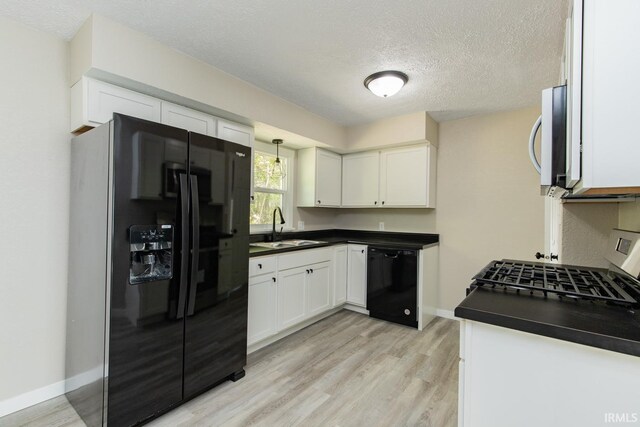 kitchen featuring light wood-type flooring, sink, white cabinetry, and black appliances