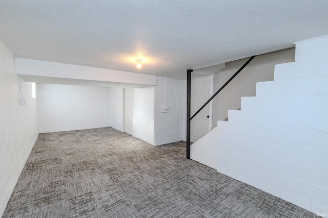 basement featuring a textured ceiling and light colored carpet