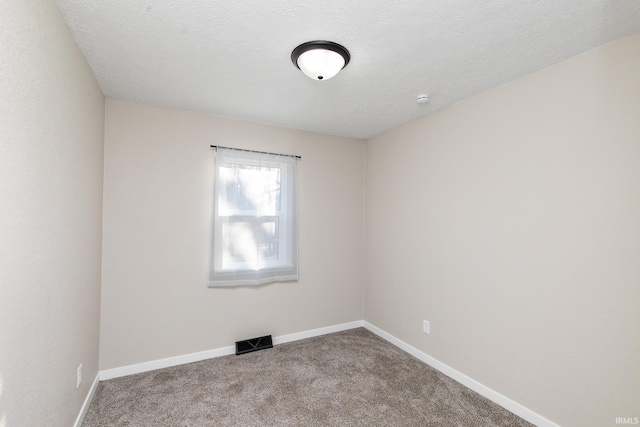 unfurnished room featuring carpet and a textured ceiling