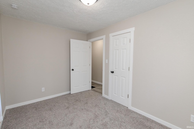 empty room featuring light carpet and a textured ceiling