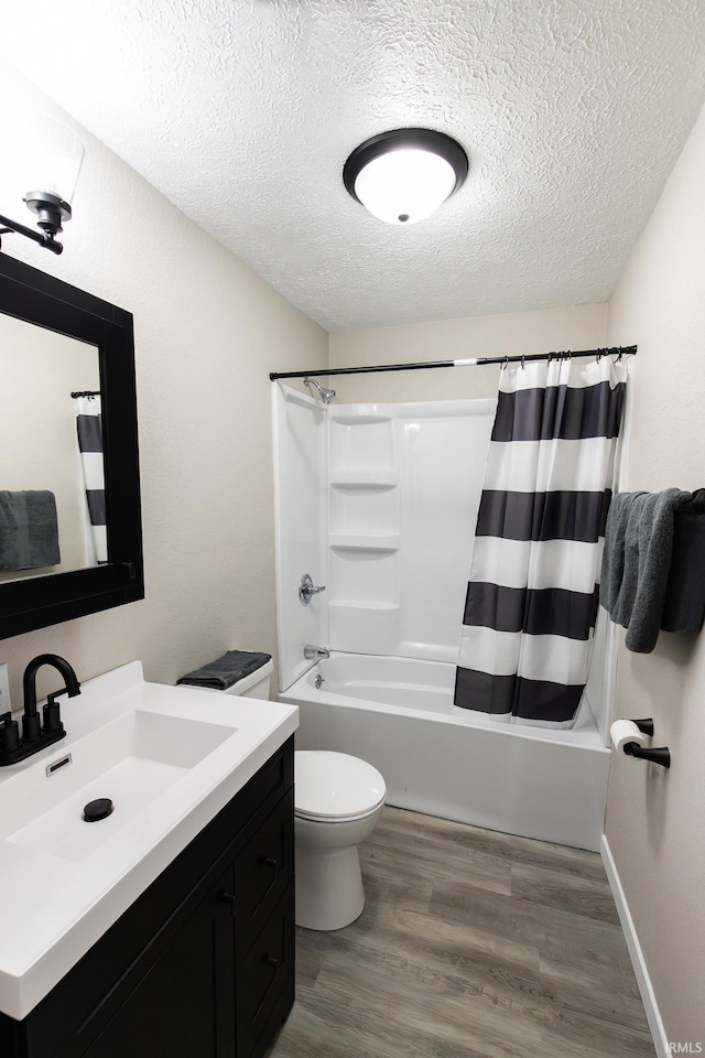 full bathroom with shower / bath combo, vanity, hardwood / wood-style flooring, toilet, and a textured ceiling