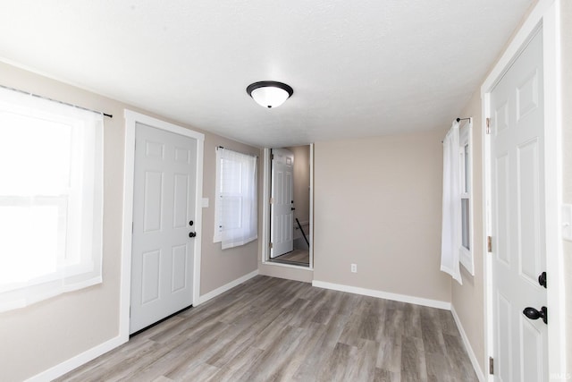 entrance foyer with a textured ceiling and light hardwood / wood-style flooring