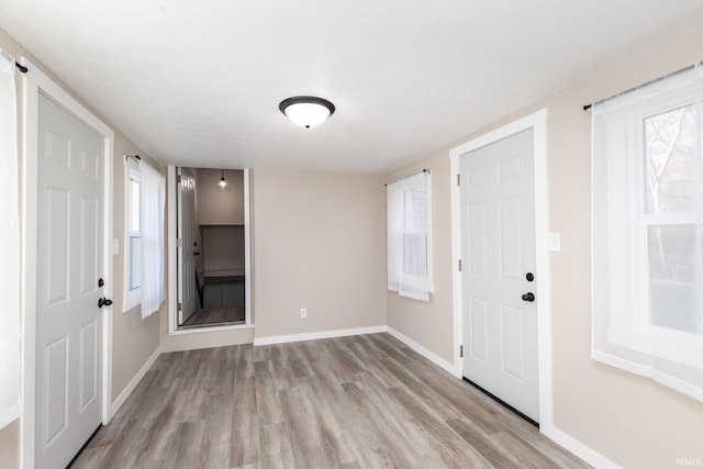 entrance foyer with a textured ceiling and light wood-type flooring