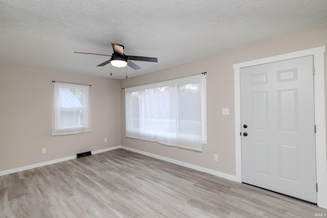 entrance foyer featuring a textured ceiling and light hardwood / wood-style floors