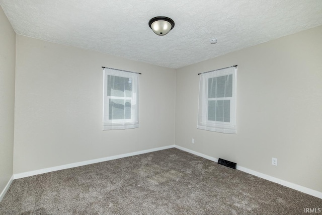 carpeted empty room with a textured ceiling