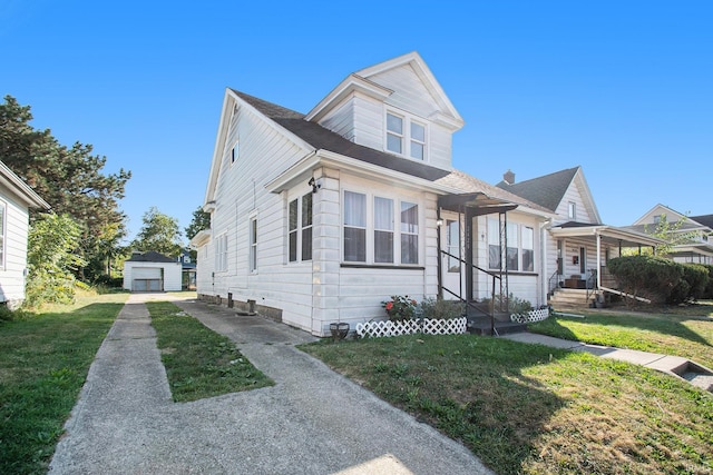 view of front of property featuring a storage shed, a front lawn, and a garage