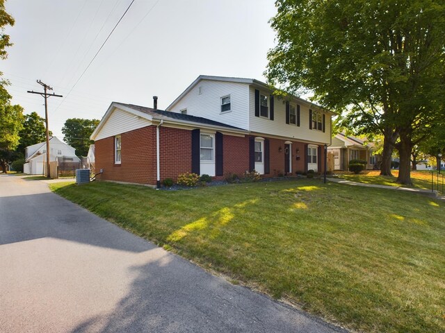 view of front of house featuring a front lawn and central AC unit