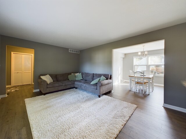 living room featuring an inviting chandelier and dark hardwood / wood-style floors