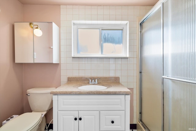 bathroom with vanity, toilet, and a shower with shower door