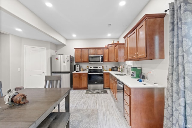 kitchen with light wood-type flooring, sink, and stainless steel appliances