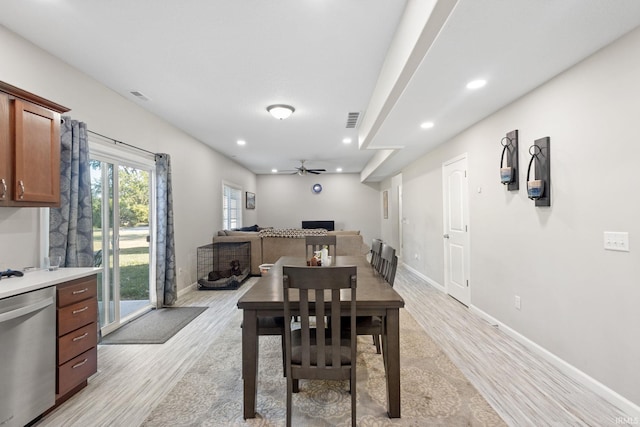 dining area with light wood-type flooring and ceiling fan