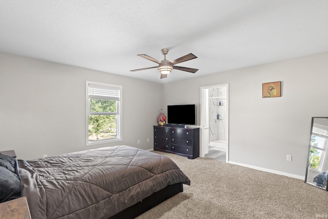 carpeted bedroom with a textured ceiling, connected bathroom, and ceiling fan