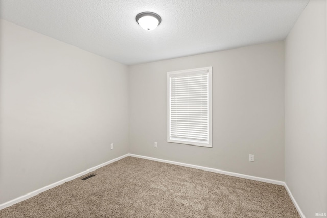 carpeted spare room with a textured ceiling