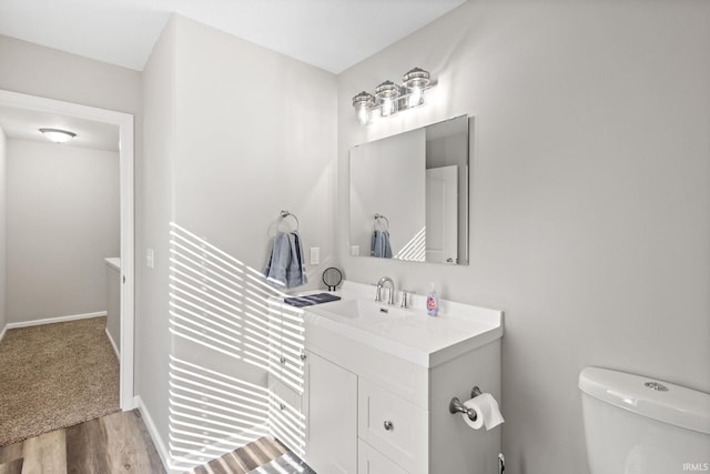 bathroom with vanity, toilet, and hardwood / wood-style flooring