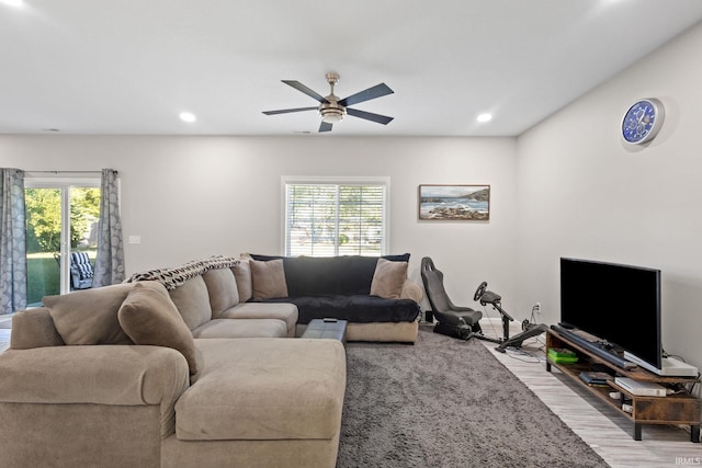 living room with ceiling fan, light wood-type flooring, and a wealth of natural light