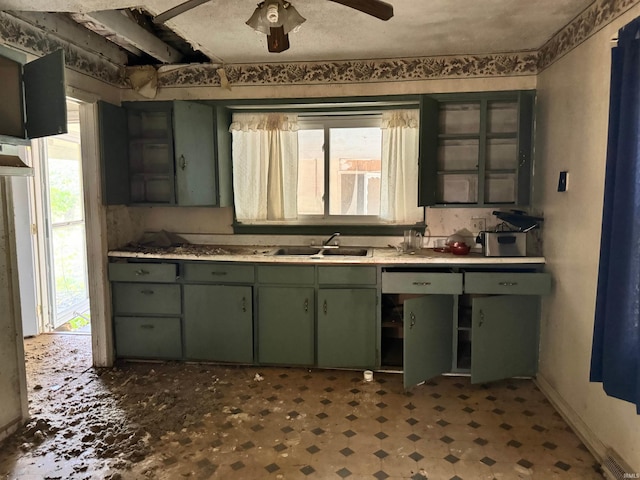 kitchen featuring ceiling fan, green cabinetry, and sink