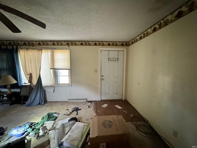 entrance foyer with ceiling fan, a textured ceiling, and a baseboard heating unit