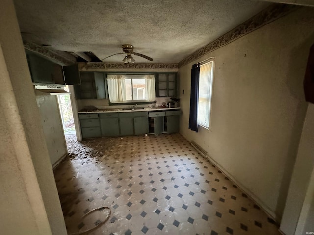 kitchen with ceiling fan, a textured ceiling, and sink