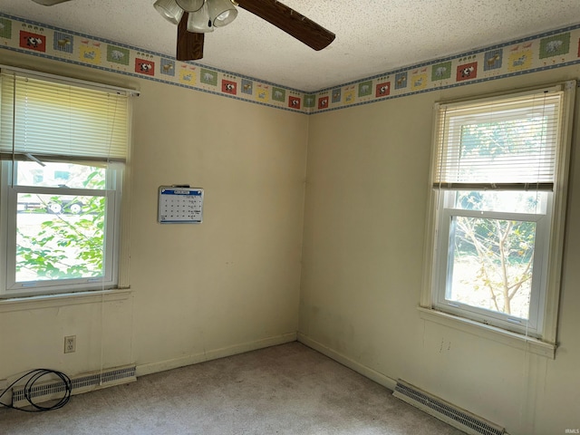 carpeted spare room featuring a textured ceiling and ceiling fan