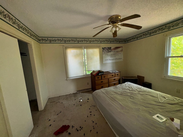 carpeted bedroom featuring ceiling fan and a textured ceiling