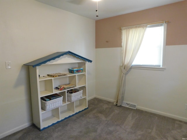 playroom featuring dark colored carpet and ceiling fan