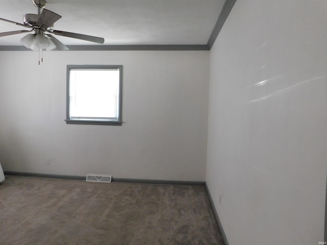 empty room featuring ceiling fan, crown molding, and dark colored carpet