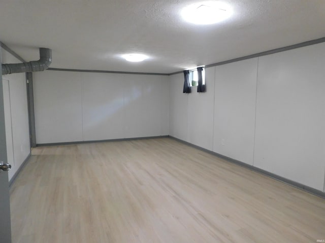 basement with a textured ceiling and light hardwood / wood-style floors