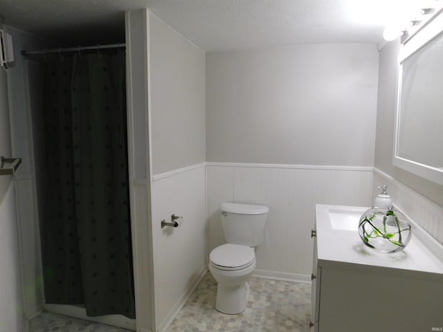 bathroom with curtained shower, a textured ceiling, vanity, and toilet