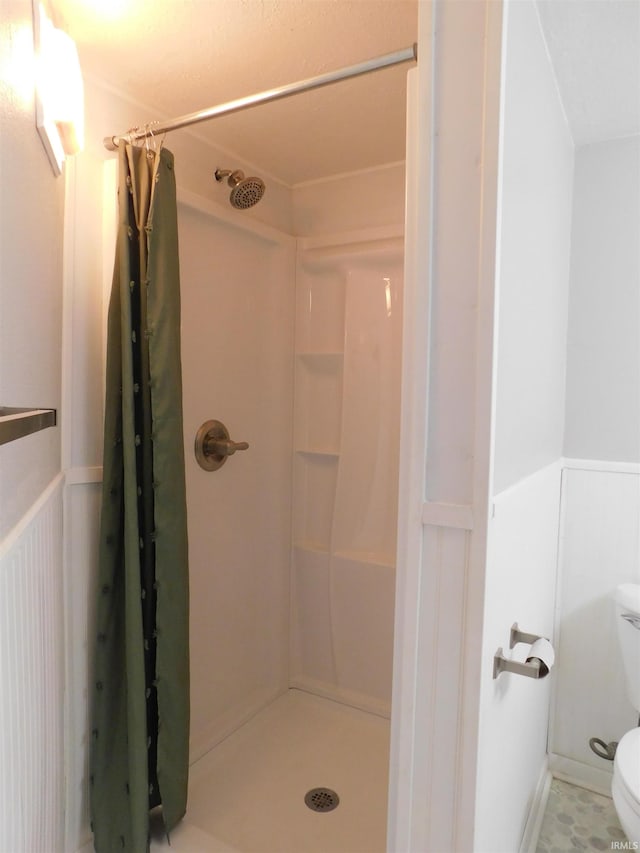 bathroom featuring walk in shower and toilet