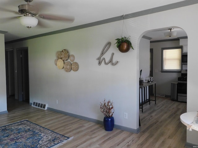 interior space featuring ornamental molding, ceiling fan, and hardwood / wood-style flooring