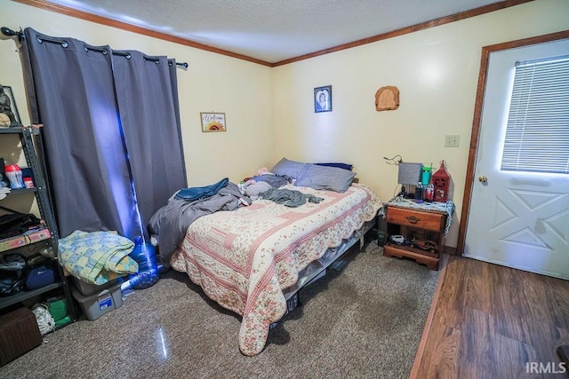 bedroom featuring dark hardwood / wood-style floors, ornamental molding, and a textured ceiling