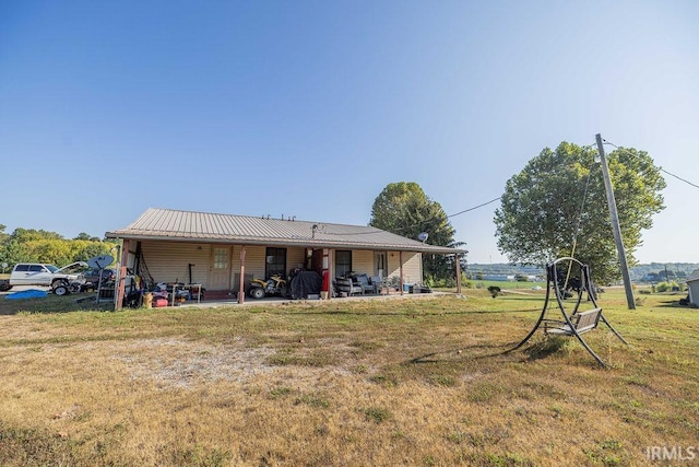 back of property featuring a yard and a patio