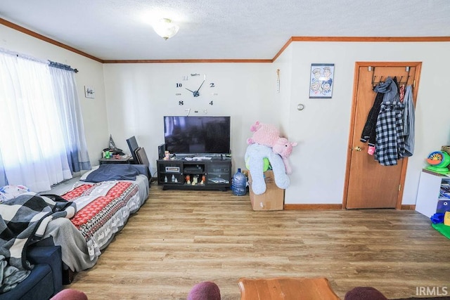 bedroom featuring a textured ceiling, wood-type flooring, and crown molding