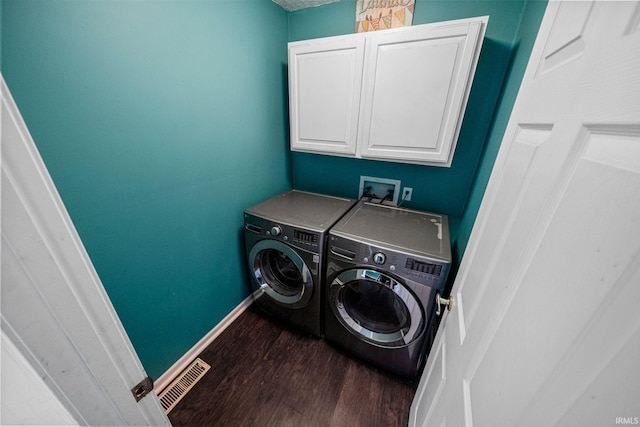 laundry area with cabinets, independent washer and dryer, and dark hardwood / wood-style flooring