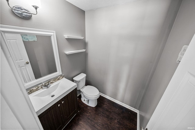 bathroom with wood-type flooring, vanity, and toilet