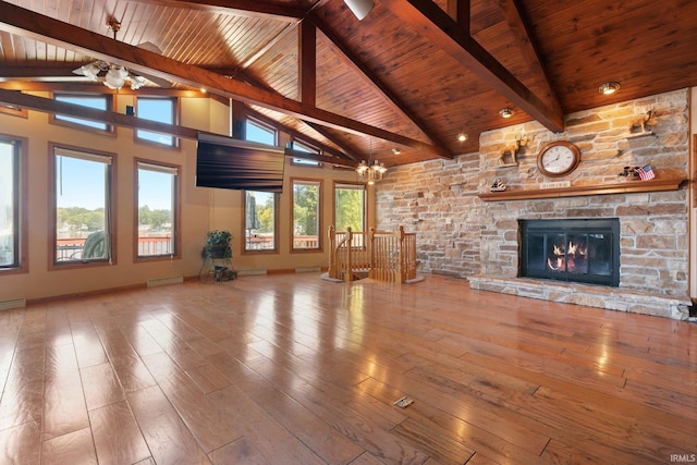 unfurnished living room featuring a notable chandelier, a wealth of natural light, hardwood / wood-style flooring, and a fireplace