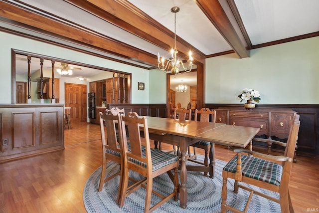 dining space featuring a chandelier, light hardwood / wood-style floors, beamed ceiling, and crown molding