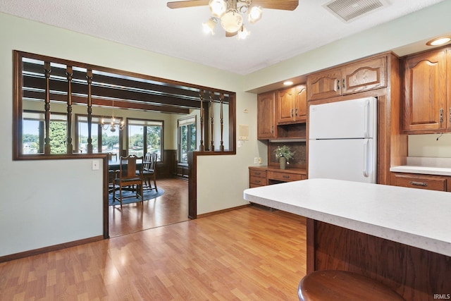 kitchen featuring ceiling fan, a textured ceiling, light wood-type flooring, and white fridge