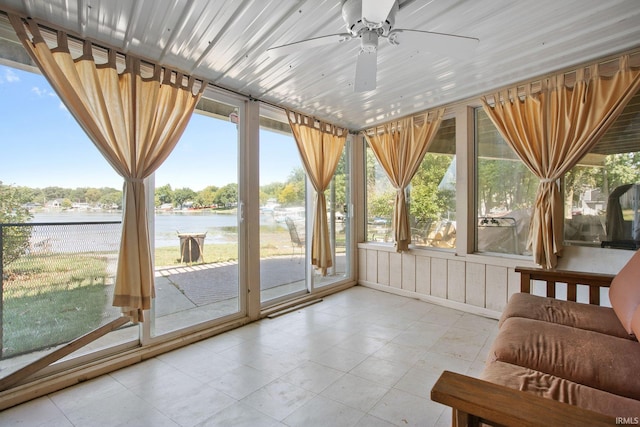 unfurnished sunroom featuring a water view and ceiling fan