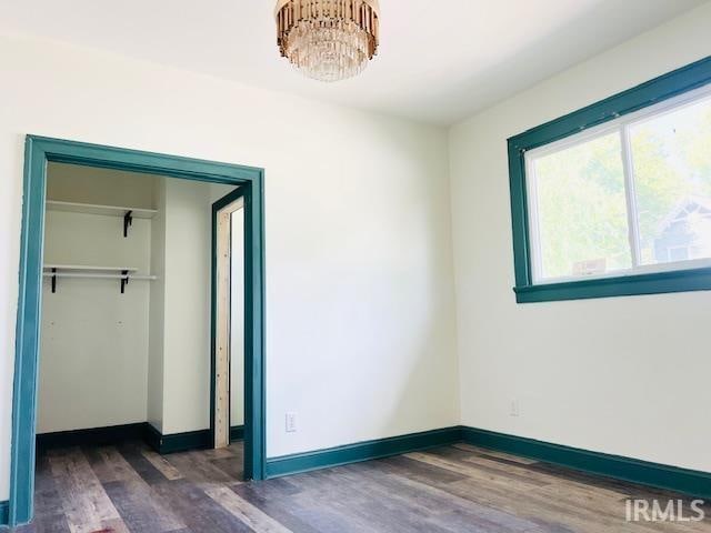 unfurnished bedroom with dark hardwood / wood-style flooring and a closet