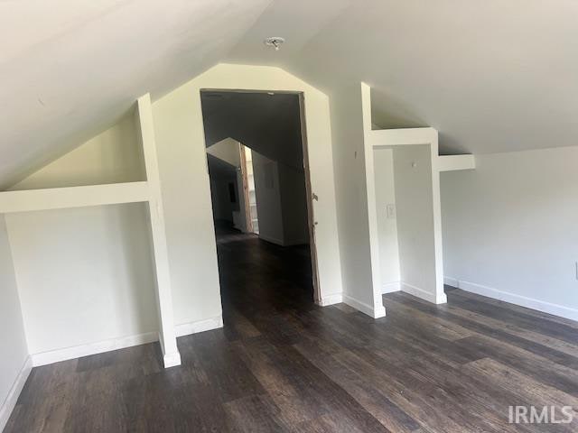 bonus room with vaulted ceiling and dark hardwood / wood-style flooring