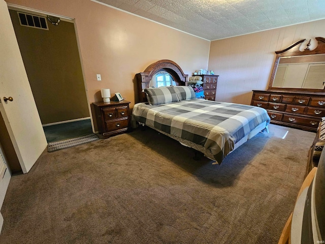 carpeted bedroom featuring a textured ceiling and wooden walls